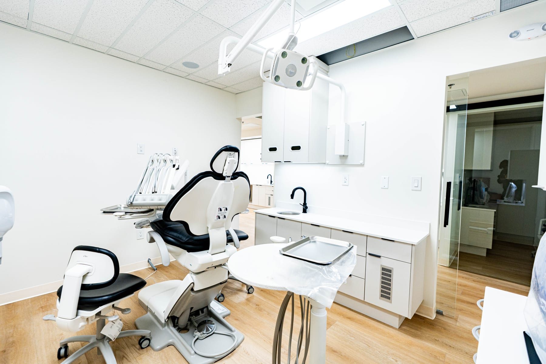 Dental operatory with chair, overhead light and service cabinetry
