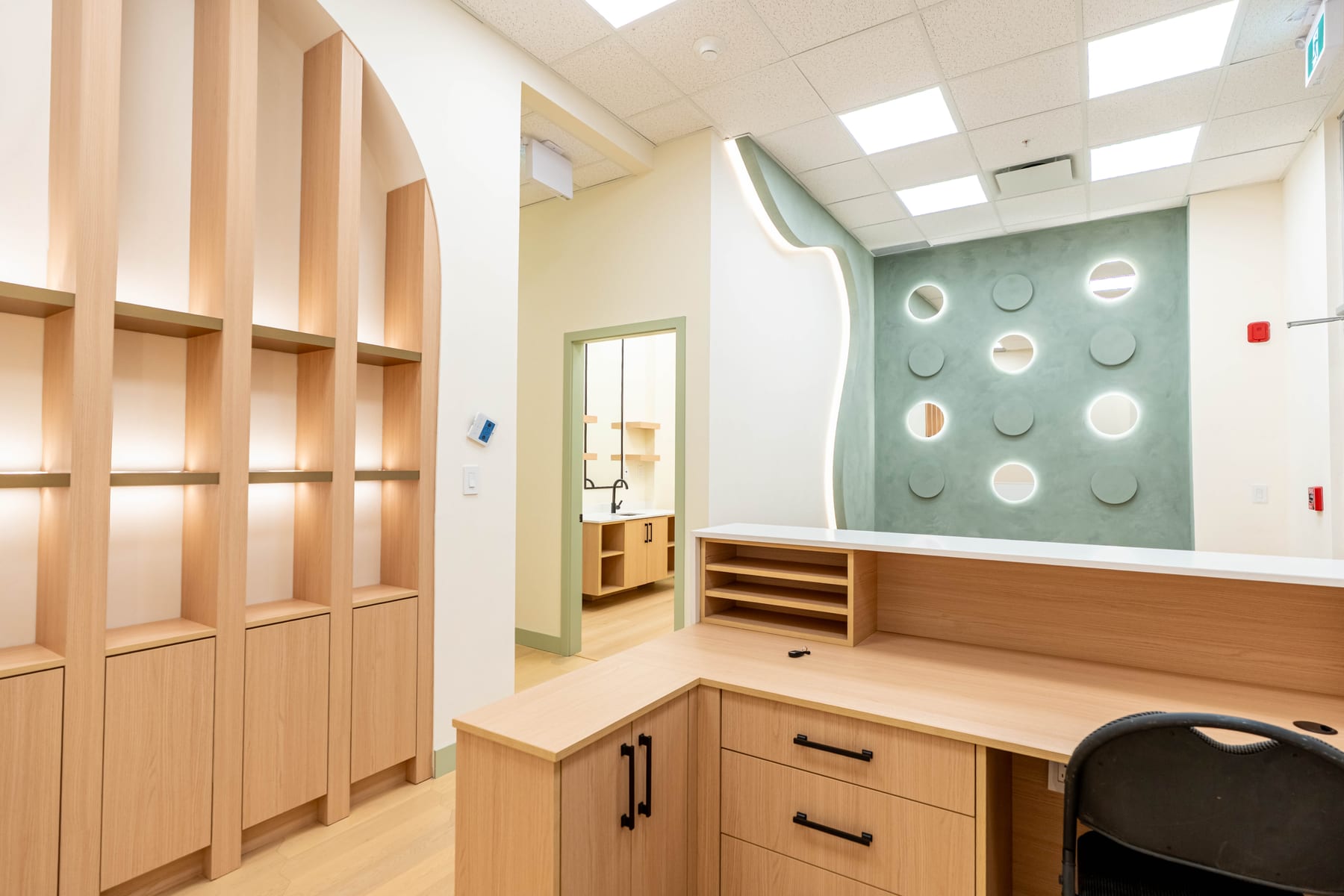 Arched millwork storage and reception counter in a completed clinic build
