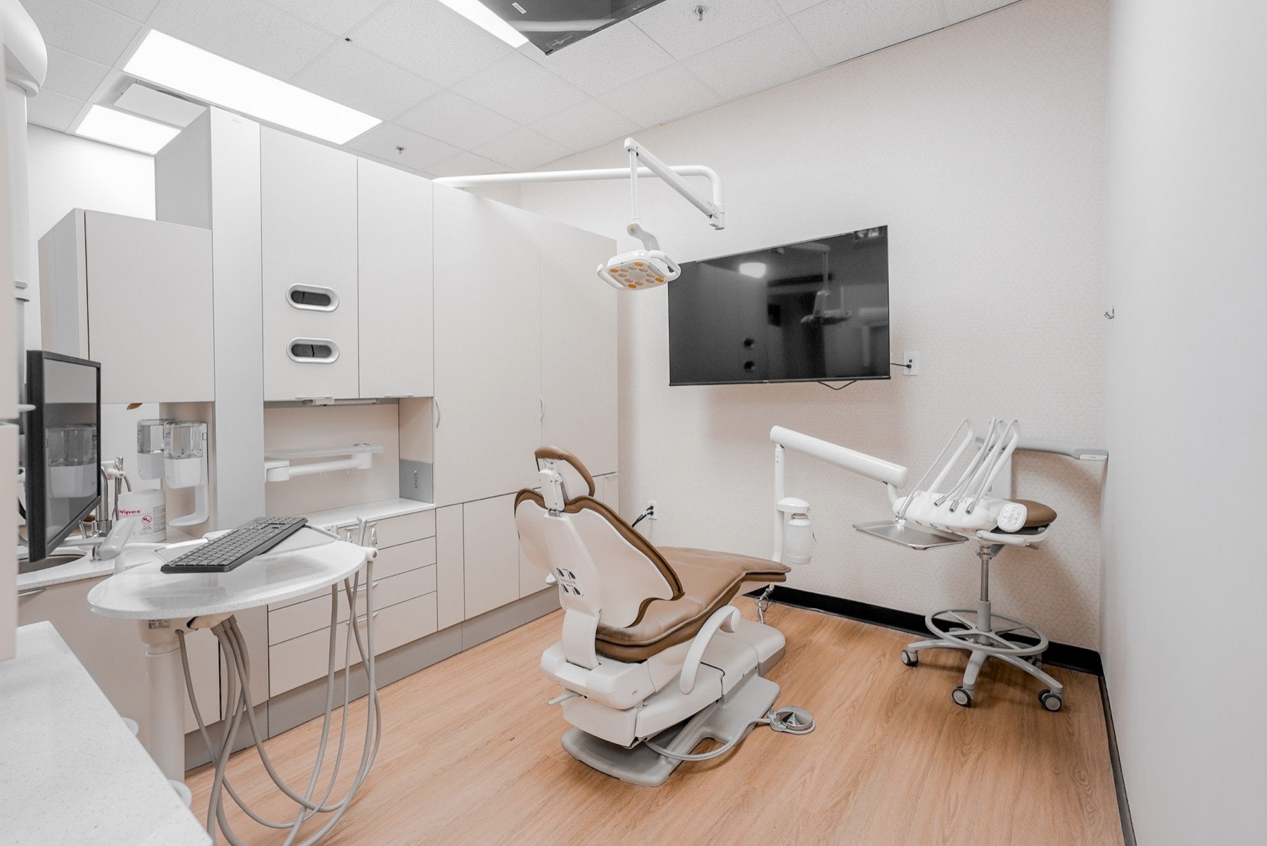 Finished dental operatory with chair, overhead light and service cabinetry at The Shine Dental, White Rock