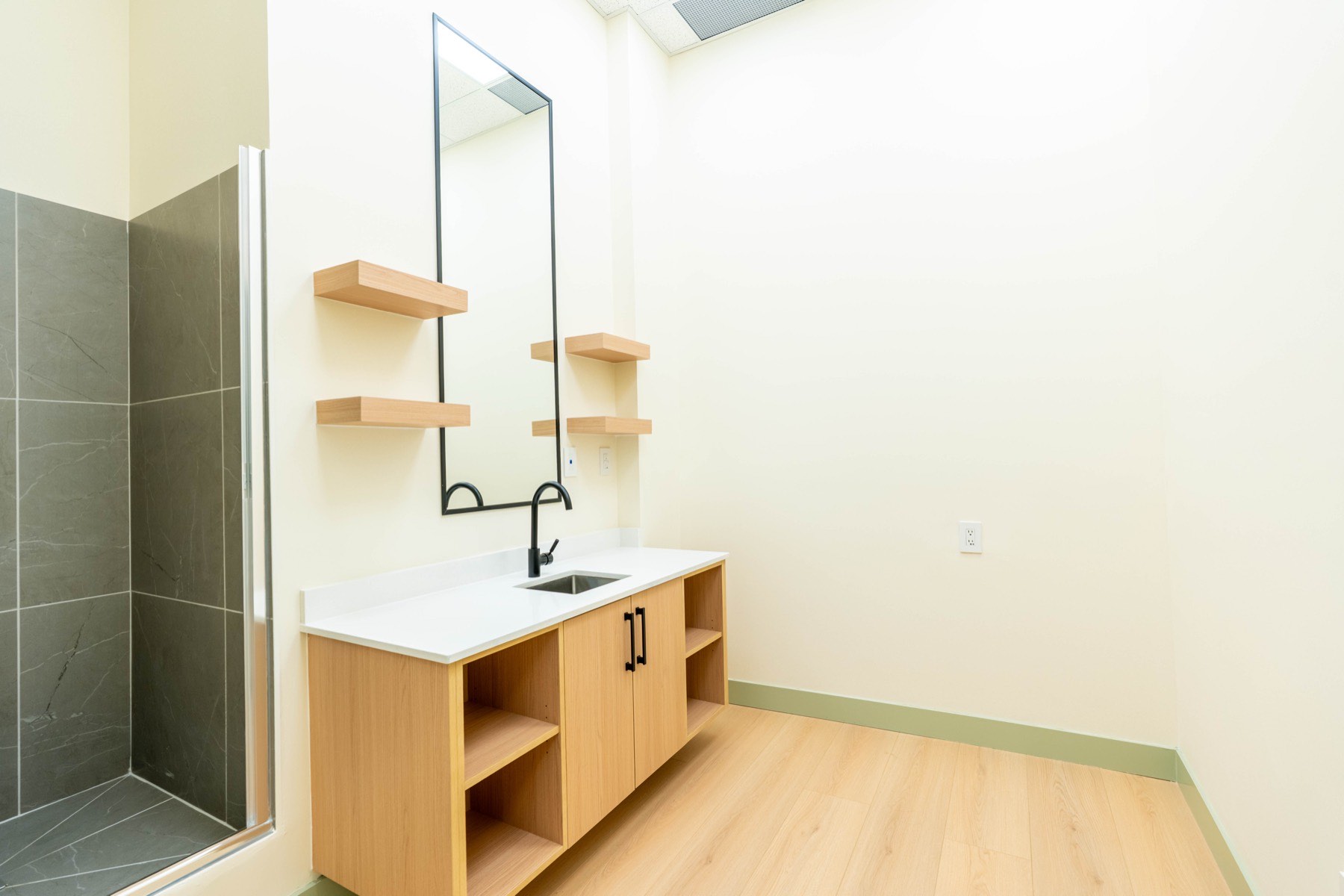 Treatment room with vanity, sink and shower at Skinholic Aesthetics medical spa, Abbotsford, BC